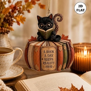 Puede incluir: Un adorno colgante plano 2D que presenta un gato negro con gafas redondas leyendo un libro verde. El gato se sienta sobre una disposición circular de lomos de libros en tonos naranja, verde y marrón. El libro central dice, A BOOK A DAY KEEPS REALITY AWAY.