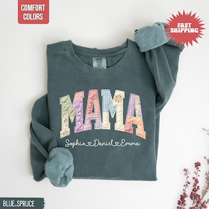 Puede incluir: Sudadera azul-verdosa con la palabra "MAMA" en letras de patchwork. Las letras están en varios patrones florales y de cuadros. Debajo de la palabra "MAMA" están los nombres "Sophia, Daniel, Emma". La sudadera tiene las palabras "Comfort Colors" en la parte superior izquierda.