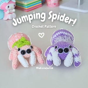 Puede incluir: Dos arañas saltarinas de crochet, una rosa con detalles verdes y otra morada con detalles blancos. Las arañas tienen grandes ojos negros y están posadas con las patas extendidas. El texto "Jumping Spider! Crochet Pattern" está por encima de las arañas.