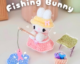 May include: A crocheted bunny wearing a yellow hat and pink dress, fishing with a wooden rod. A pink fish is on the hook. The image includes the text "Fishing Bunny" and a small green crocheted chair and a basket with fish.
