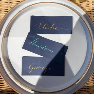 Tarjetas de lugar: tarjetas de nombre planas de color azul marino para bodas o eventos con caligrafía personalizada.
