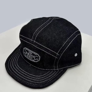 May include: Black denim cap with white stitching and a flat peak. The cap features a white patch with the text "GENTLEMAN HEAD WEAR THE H.W. DOG & CO. 2015". The cap has a five-panel design.