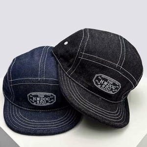 May include: Two denim caps, one dark blue and one black, with white stitching. Each cap has a white label with the text "THE H.W.DOG & CO." and "GENTLEMANHEAD WEAR". The caps have a classic, five-panel design.
