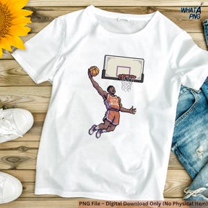 Può includere: T-shirt bianco con un'illustrazione pixelata di un giocatore di basket che schiaccia. Il giocatore indossa una maglia arancione con la scritta "CITY BALLER". È visibile un canestro da basket. Il testo "WHATA PNG" e "PNG File - Digital Download Only (No Physical Item)".