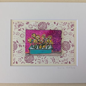 May include: A framed art print featuring a colorful floral still life. The artwork depicts yellow flowers in a turquoise container against a pink background. The print is matted and framed in white, with a patterned background.