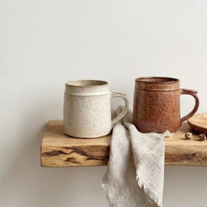 Taza moteada con glaseado blanco cálido o marrón chocolate.
