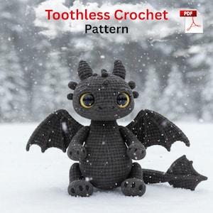 May include: A crocheted black dragon with large yellow-centered eyes, wings, and a tail, sitting in the snow. The text "Toothless Crochet Pattern" is displayed at the top of the image.