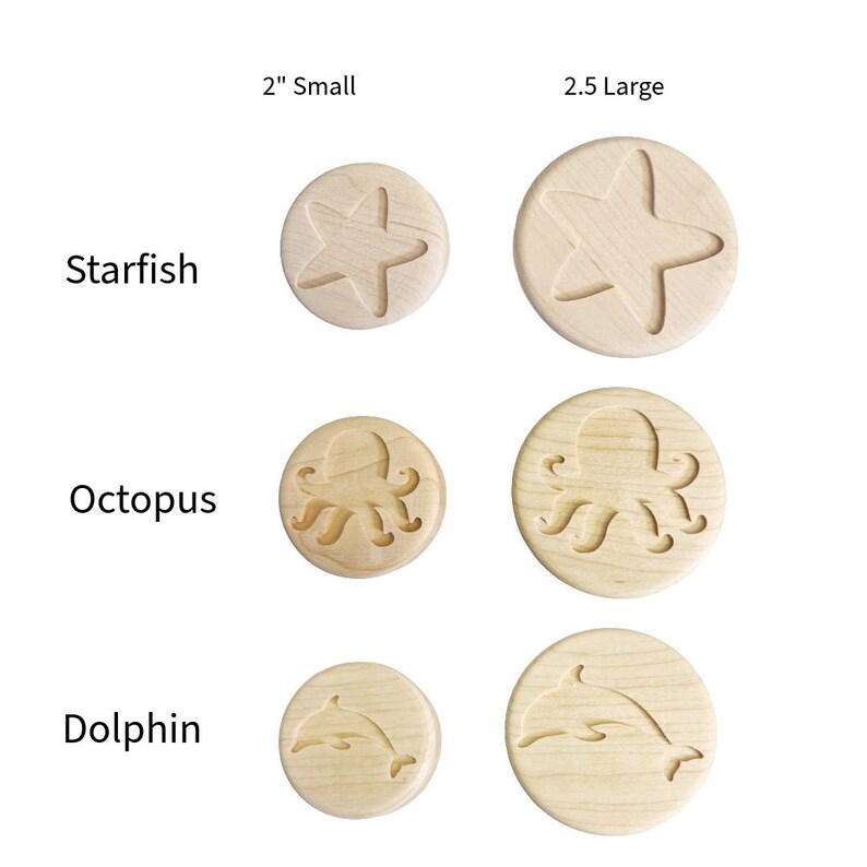 May include: A collection of round wooden discs featuring engraved marine life designs including a starfish, octopus, and dolphin. The discs are labeled as 2 inch small and 2.5 inch large, showcasing the natural light wood grain texture.