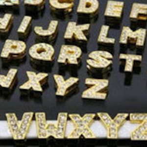 Lettera scorrevole in oro da 10 mm con centro in strass (solo 1)