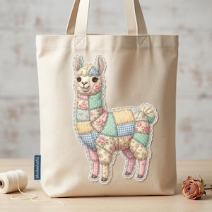 May include: A beige canvas tote bag featuring a colorful patchwork llama design. The llama is made of various floral and patterned fabrics in pastel colors. The bag has sturdy handles and a small blue label that reads "bluebasketful".
