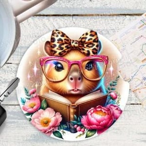Puede incluir: Un posavasos redondo y blanco para coche con un hámster de dibujos animados con gafas rosas y un lazo de leopardo, leyendo un libro. Flores rosas y un mapa en el fondo.