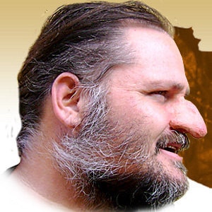 Puede incluir: Un primer plano de perfil de un hombre con una nariz grande y prominente. Tiene barba y bigote completos, con algunas canas. Su cabello es castaño oscuro y se está retrocediendo.