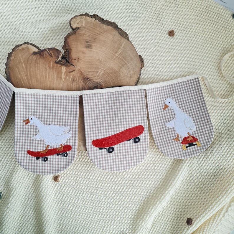Handmade garland featuring a cool white goose on a skateboard applique over light beige gingham fabric, unique goose nursery decor for kids room bunting