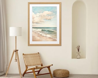 Può includere: Una stampa artistica incorniciata con una scena di spiaggia e la citazione: "Ciò che neghiamo in noi stessi ci controlla". L'opera d'arte raffigura un cielo blu, onde oceaniche e una spiaggia sabbiosa. La cornice è di colore marrone chiaro.