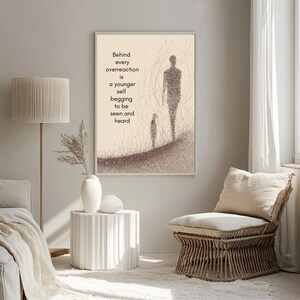 May include: Framed art print with a beige background featuring two stylized figures and the text: "Behind every overreaction is a younger self begging to be seen and heard." The artwork is in shades of brown and beige.