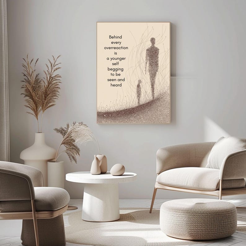 May include: A framed artwork with a beige background features two figures and the text: "Behind every overreaction is a younger self begging to be seen and heard." The artwork is displayed in a modern living room setting.