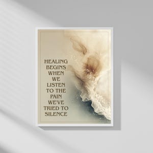 May include: A framed art print with the text "Healing begins when we listen to the pain we've tried to silence." The artwork features abstract watercolor-style designs in shades of beige, brown, and blue, with a white border.