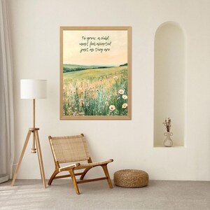 May include: A framed landscape art print with a field of wildflowers and the quote, "To grow, a child must feel accepted just as they are." The artwork is in a light wood frame, with a neutral color palette.