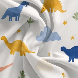 May include: White fabric with a repeating pattern of colorful dinosaurs, clouds, and stars. The dinosaurs are in shades of blue, yellow, green, and pink. The clouds are peach and blue, and the stars are yellow.