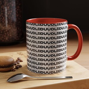 Duudl Studio Mug! One logo? Nah. We went full Duudl. Get a brew with a face full of Duudl!