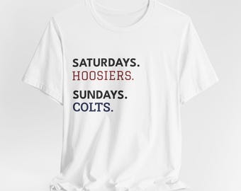 May include: White t-shirt with the text "SATURDAYS. HOOSIERS. SUNDAYS. COLTS." in black, red, and blue lettering. The shirt is made of a soft material and has a crew neck.