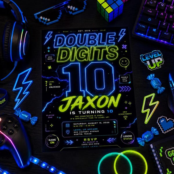 Könnte beinhalten: Eine rechteckige Geburtstagseinladungskarte mit schwarzem Hintergrund und neongrünem sowie blauem Text, der Double Digits 10 Jaxon Is Turning 10 lautet, inklusive Blitzen, Gamecontroller-Symbolen und Veranstaltungsdetails für den 15. August 2026.