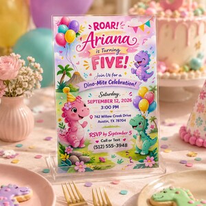 May include: A rectangular acrylic sign featuring a colorful birthday invitation for Ariana turning five. The design includes cartoon dinosaurs, balloons, and text: ROAR! Ariana is Turning FIVE! Join Us for a Dino-Mite Celebration! Saturday, SEPTEMBER 12, 2026, 3:00 PM, 742 Willow Creek Drive, Austin, TX 78704, RSVP by September 5, Call or Text (512) 555-3948.