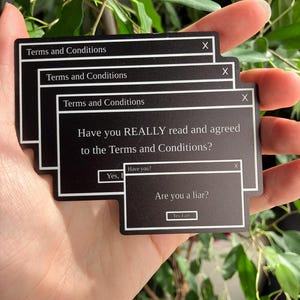 Peut inclure: Autocollants rectangulaires noirs avec du texte blanc. Ils affichent "Conditions générales" et "Avez-vous VRAIMENT lu et accepté les conditions générales ?" Un autocollant demande "Êtes-vous un menteur ?" avec "Oui, je le suis" comme option.