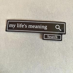 May include: A black rectangular sticker with the text "my life's meaning" in white, resembling a search bar. A magnifying glass icon is on the right, and a smaller rectangle below reads "Search".