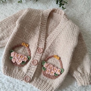 Handgemachte Baby Strickjacke mit Blumenkorb Design – Gehäkelter Baby Pullover, Geschenk zur Geburt, Vintage-inspirierte Baby Kleidung