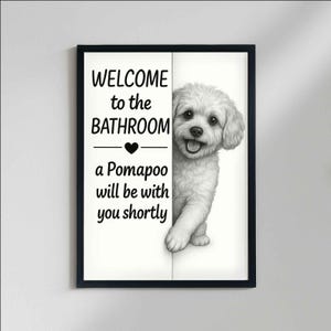 May include: Black framed bathroom wall art featuring a Pomapoo dog illustration. The artwork includes the text "WELCOME to the BATHROOM" above a heart symbol, followed by "a Pomapoo will be with you shortly."