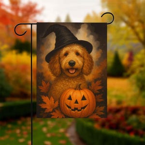 May include: A Halloween garden flag featuring a golden doodle wearing a black witch hat. The dog is smiling with a carved orange pumpkin in front of it. Autumn leaves surround the dog and pumpkin.