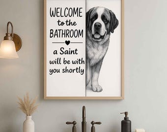 Op de afbeelding: Ingelijste wandkunst met een illustratie van een Sint-Bernardhond. De tekst luidt "WELCOME to the BATHROOM a Saint will be with you shortly". De lijst is lichtbruin. Voor de badkamer.