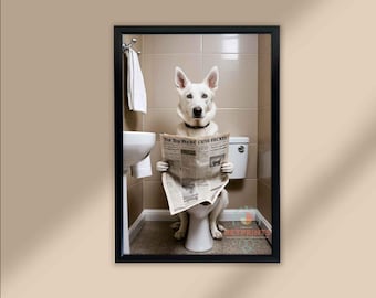 Puede incluir: Impresión enmarcada que muestra un perro blanco sentado en un inodoro, leyendo un periódico. El perro lleva un collar negro. El baño tiene azulejos beige, un lavabo y un inodoro blancos. El titular del periódico es visible.