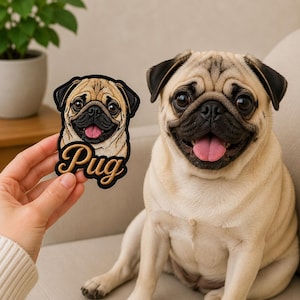 May include: An embroidered patch featuring a tan pug with a black muzzle and a pink tongue, with the word Pug written in cursive gold lettering below the dog's face. The patch has a black border and is held up next to a live tan pug dog.