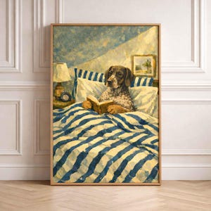 May include: A framed print shows a dog reading in bed. The dog, with brown and white markings, is under a blue and white striped duvet. The artwork has a vintage style, with a lamp and a small painting on the wall.