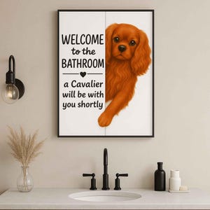 May include: A framed bathroom sign with the text "WELCOME to the BATHROOM" and "a Cavalier will be with you shortly." A Cavalier King Charles Spaniel dog peeks from behind the sign. The dog has reddish-brown fur. The sign is in a bathroom setting.