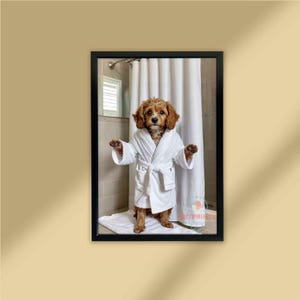 May include: A framed print featuring a brown and white dog wearing a white bathrobe. The dog stands in a bathroom setting with a white shower curtain in the background. The dog has its arms outstretched.