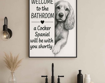 May include: A framed black and white print featuring a Cocker Spaniel peeking out from behind a white panel. The text reads "WELCOME to the BATHROOM" above a heart symbol, followed by "a Cocker Spaniel will be with you shortly."
