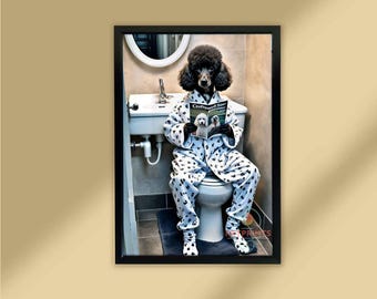 May include: A framed print featuring a black poodle wearing pajamas and reading a magazine while sitting on a toilet. The pajamas are white with black spots. The magazine is titled "Clothbound Star". The bathroom has a sink and mirror.