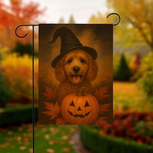 May include: A Halloween garden flag featuring a golden doodle wearing a black witch hat. A carved jack-o'-lantern and fall leaves are at the bottom of the flag. The background is a warm, autumnal color palette.