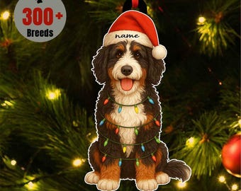 May include: A Christmas ornament featuring a Bernese Mountain Dog wearing a Santa hat with the word "name" on it. The dog is adorned with colorful Christmas lights. The ornament is set against a backdrop of a Christmas tree, with the text "300+ Breeds" in a circle.