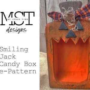 May include: Smiling Jack Candy Box e-Pattern, a digital download pattern for a wooden jack-o'-lantern candy box. The box is painted orange with black eyes and a wide, toothy grin. It has a rustic, distressed look and is decorated with a plaid bow.