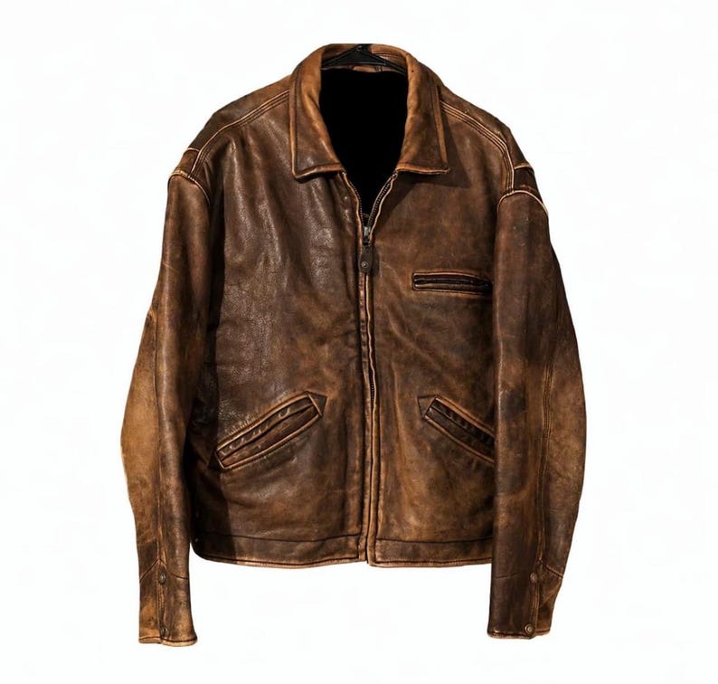 Puede incluir: Chaqueta de cuero marr&oacute;n desgastado con cremallera, cuello y m&uacute;ltiples bolsillos. La chaqueta tiene un aspecto desgastado y vintage, con desgaste visible en el cuero. La chaqueta se muestra sobre un fondo blanco.