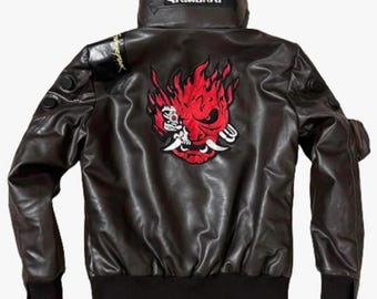May include: Black leather jacket with a high collar and a black ribbed hem. The back features a red and white graphic of a demon-like face. The word "SAMURAI" is printed on the collar.