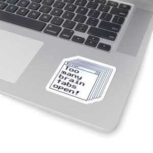 Peut inclure: Un autocollant blanc avec le texte "Error Too many brain tabs open!" dans un design de fenêtre d'ordinateur rétro. L'autocollant est posé sur un ordinateur portable argenté.