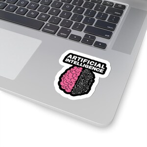 May include: A sticker featuring a stylized brain design, split into two halves. One side is a pink brain, the other a circuit board. The words "ARTIFICIAL INTELLIGENCE" are printed above the brain in bold, black letters.