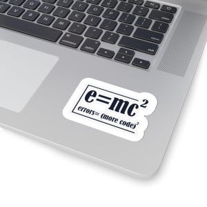 May include: A white sticker with the text "e=mc²" in a black, bold font, with the equation "errors=(more code)²" below it. The sticker is on a silver laptop.