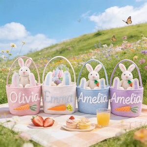 Puede incluir: Cuatro cestas de Pascua en rosa, blanco, azul y morado, cada una con un conejito de peluche y un diseño de zanahoria. Las cestas tienen bordados los nombres Olivia, Emma y Amelia. La escena incluye fresas, magdalenas y un vaso de zumo de naranja.