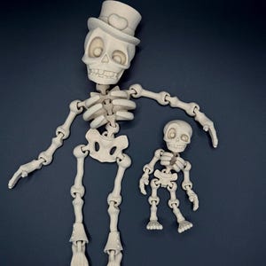 May include: Two articulated skeleton figures, one large and one small, are displayed against a dark background. The larger skeleton wears a top hat. Both figures are off-white and have detailed bone structures, perfect for Halloween or Day of the Dead decor.